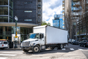 Large moving truck being driven by a professional driver to illustrate why you should choose commercial movers