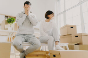 people sitting in home after moving boxes arrive and experiencing relocation depression