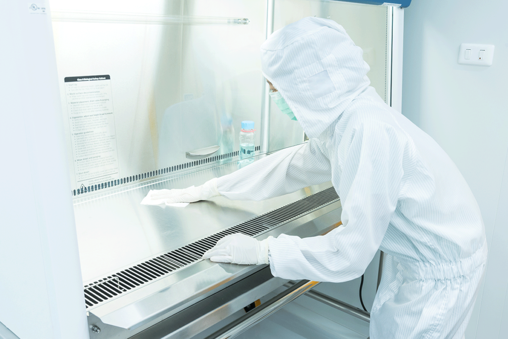 person in hazmat suit cleaning lab after learning how to clean a laboratory after a move